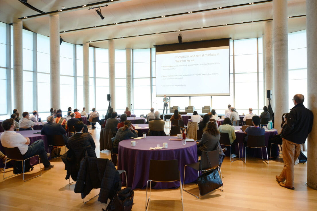people sitting around tables at a Global Poverty Research Lab event held in the Kellogg global hub
