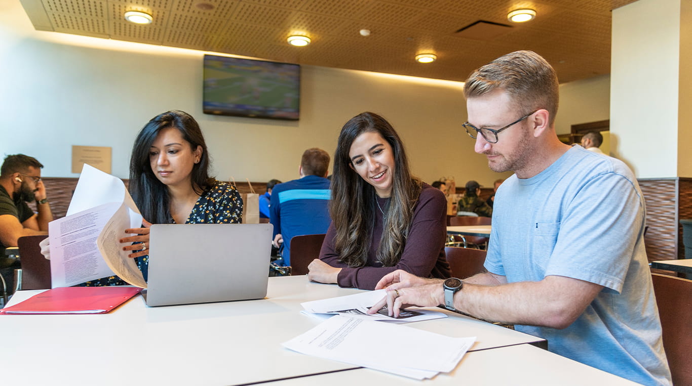 Students collaborating together and reviewing papers.