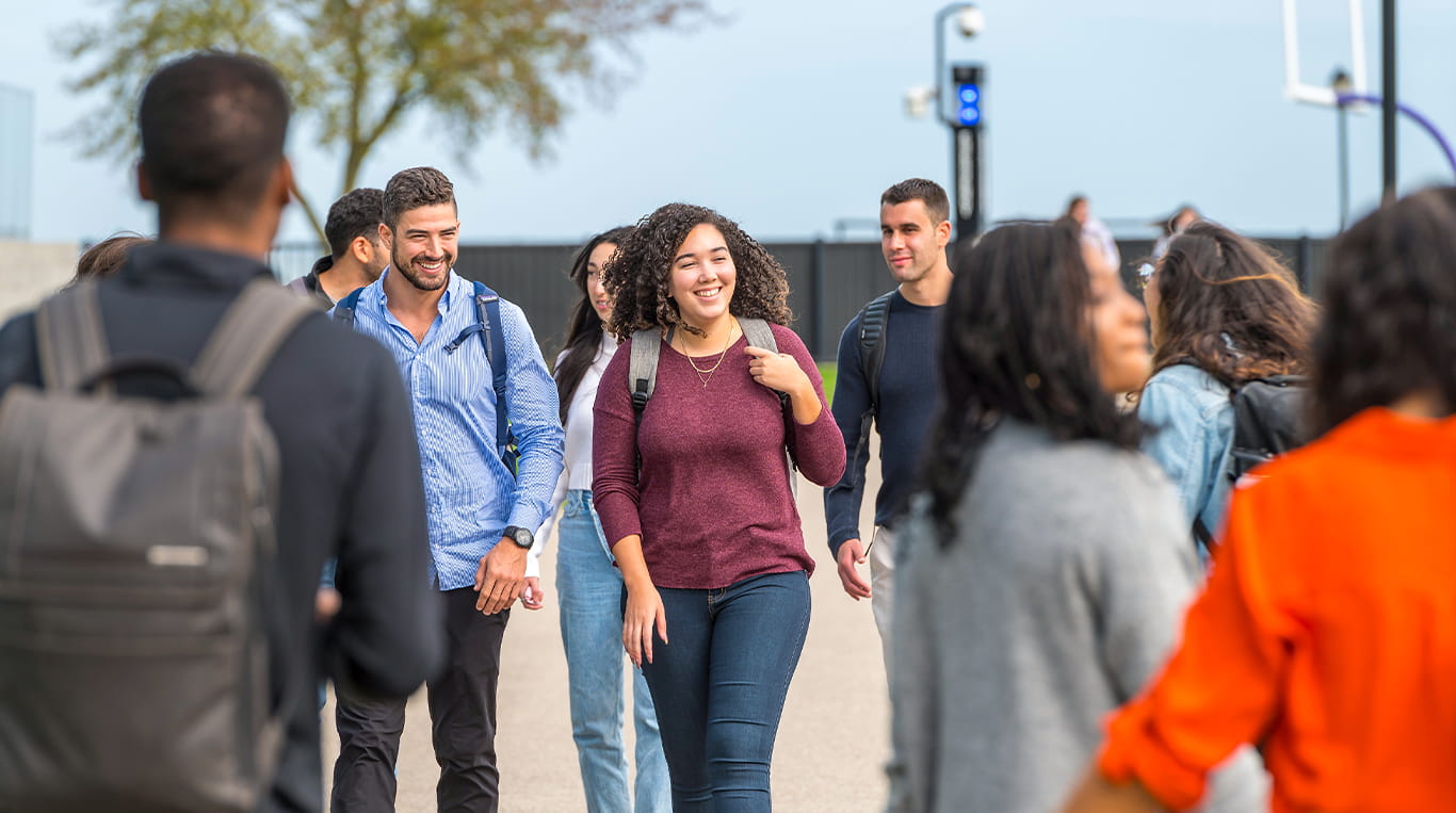 Students walking together outside and smiling