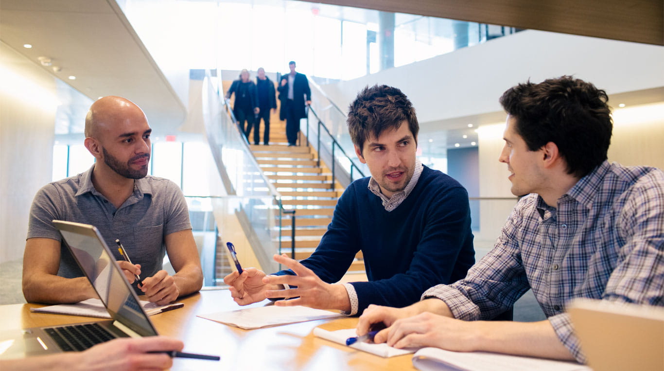 PhD students at Kellogg having a discussion at the Global Hub.