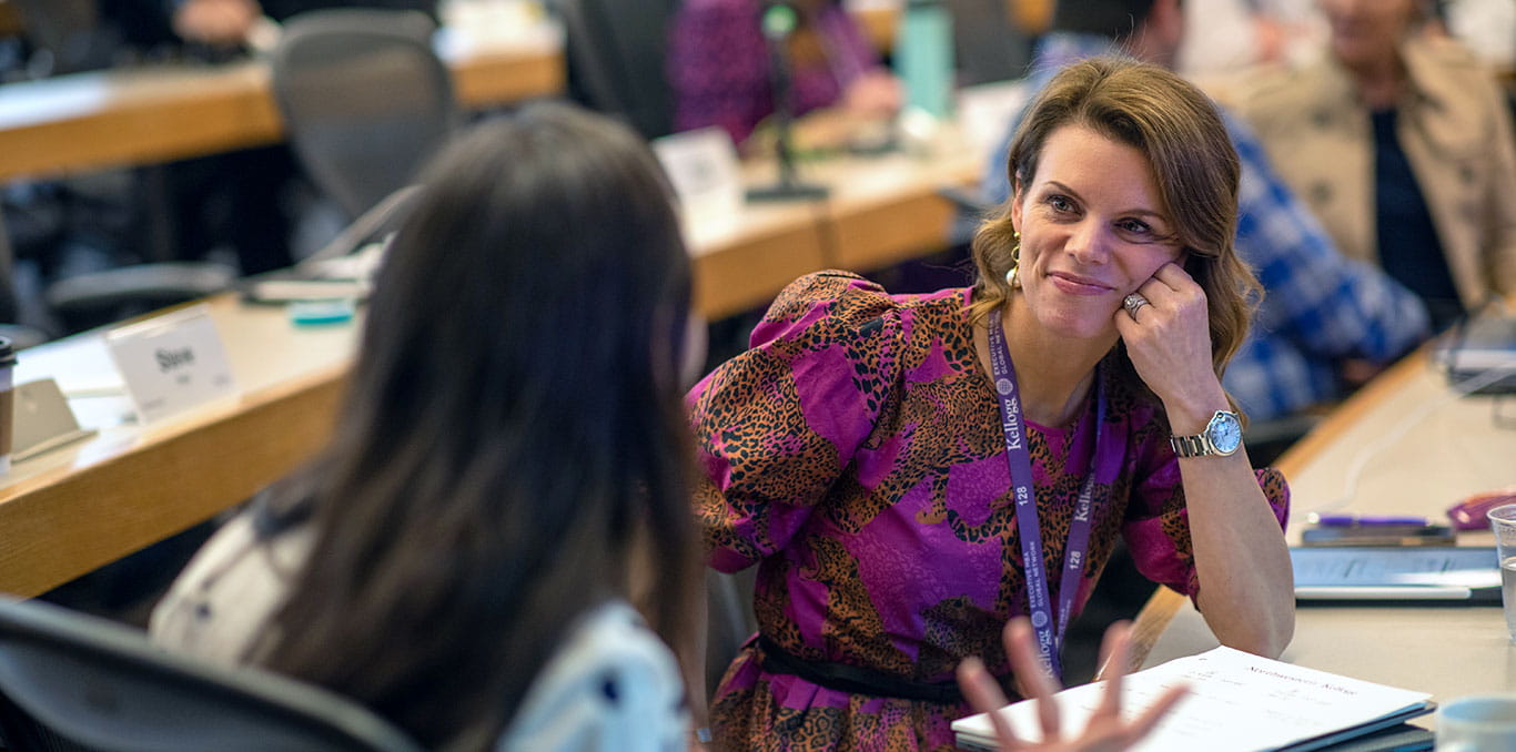Two Kellogg Executive MBA students in discussion in a classroom