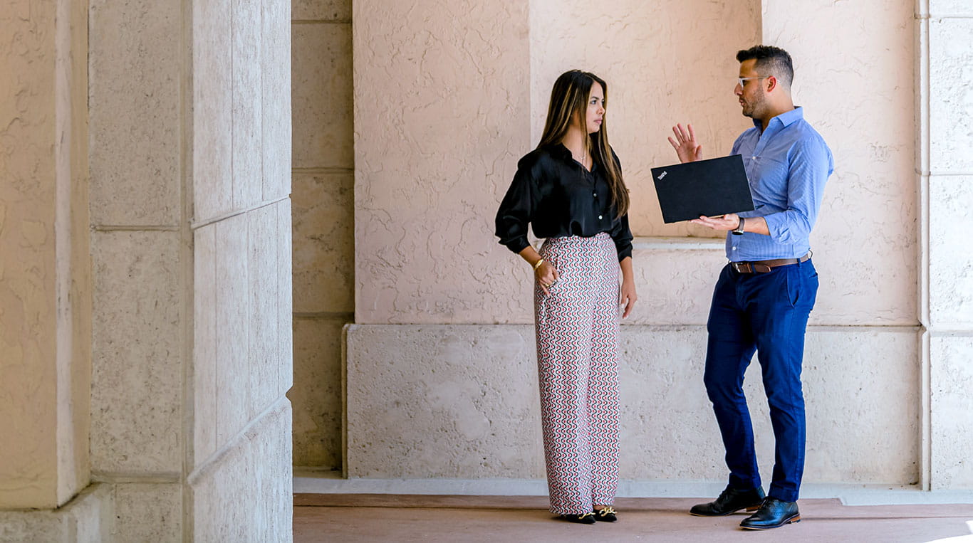 Two students stand and talk on the Kellogg Miami campus 