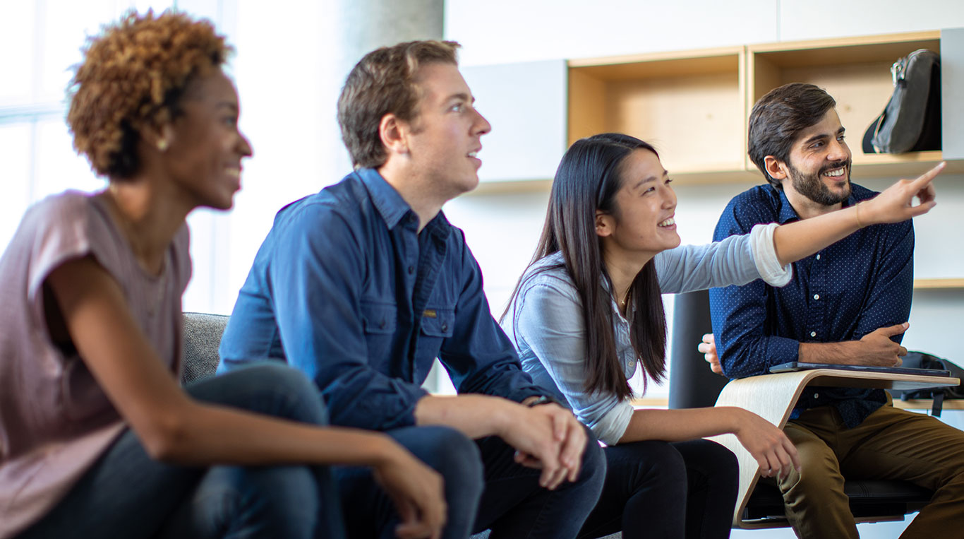 Four Kellogg students sitting together talking.