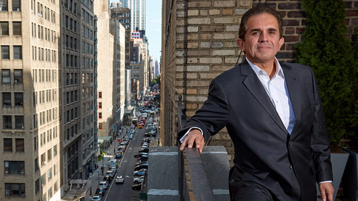 Kellogg alumnus Daniel Gamba stands on a balcony overlooking a busy city street