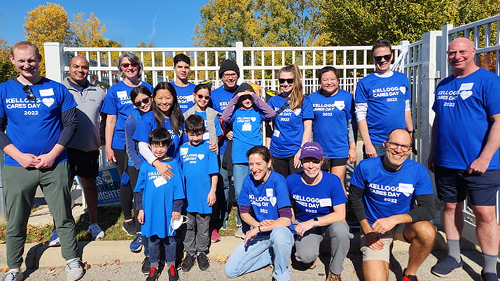 A group of Kellogg alumni volunteers in Chicago pose together for a group photo in matching blue t-shirts