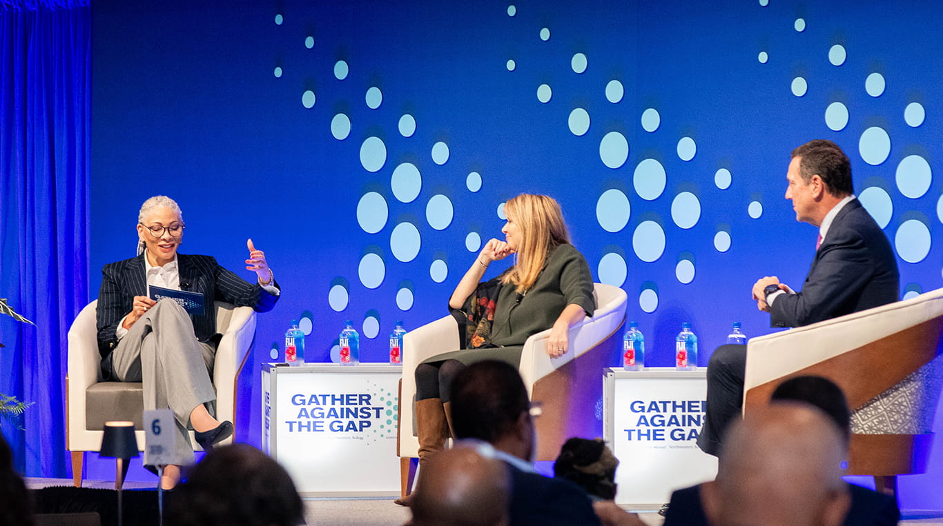 Kellogg alumna Ginny Clarke ’84 MBA, Dean Francesca Cornelli and Northwestern Mutual CEO John Schlifske ’83 MBA on stage during a fireside chat at the Gather Against the Gap event.