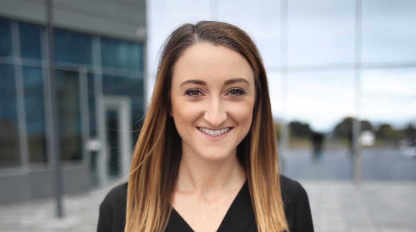 Kellogg alumna Taylor Acampora smiles and poses outside the Kellogg Global Hub in Evanston