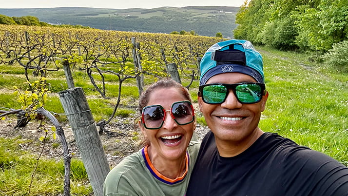 Kellogg alumni Satish Annadata and Indra Sandal pose for a selfie near the grapevines growing at their vineyard in upstate New York.