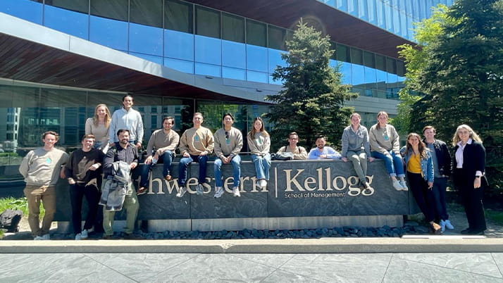 Some members of the Kellogg Energy & Sustainability Club posing at Kellogg with close club partner Professor Meghan Busse