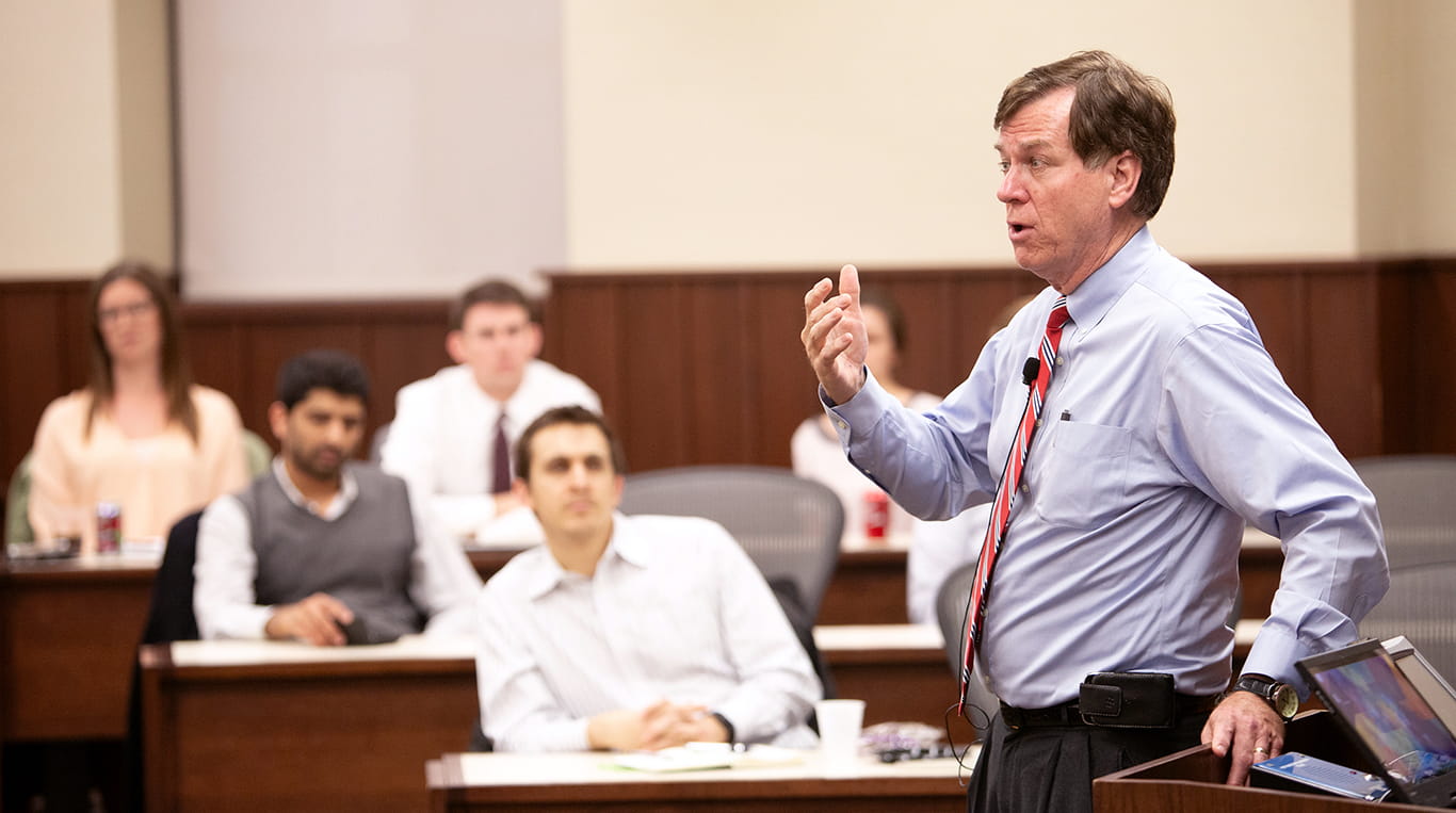 Professor Harry Kraemer stands and teaches in a Kellogg Executive Education classroom full of students