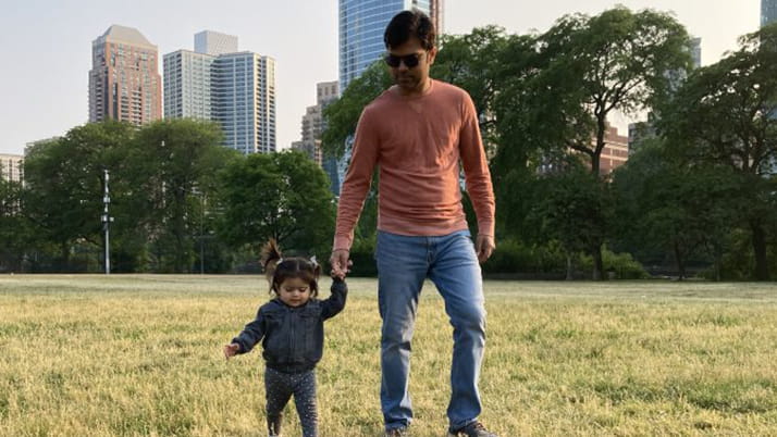 Hirak walking with his young child in a Chicago park.