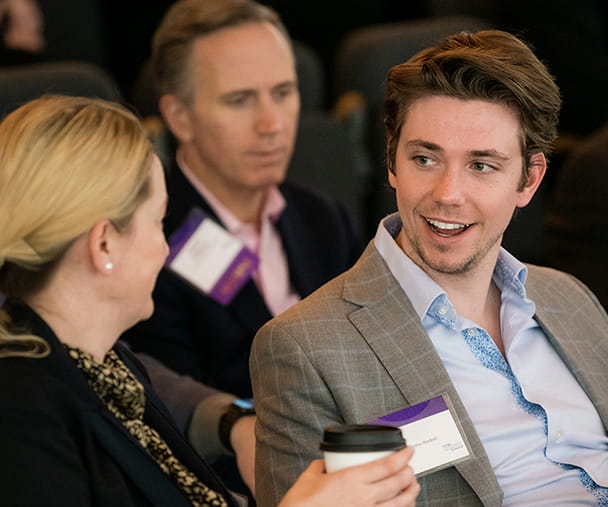 A Kellogg student and a business executive sit together engaging in a lively conversation.