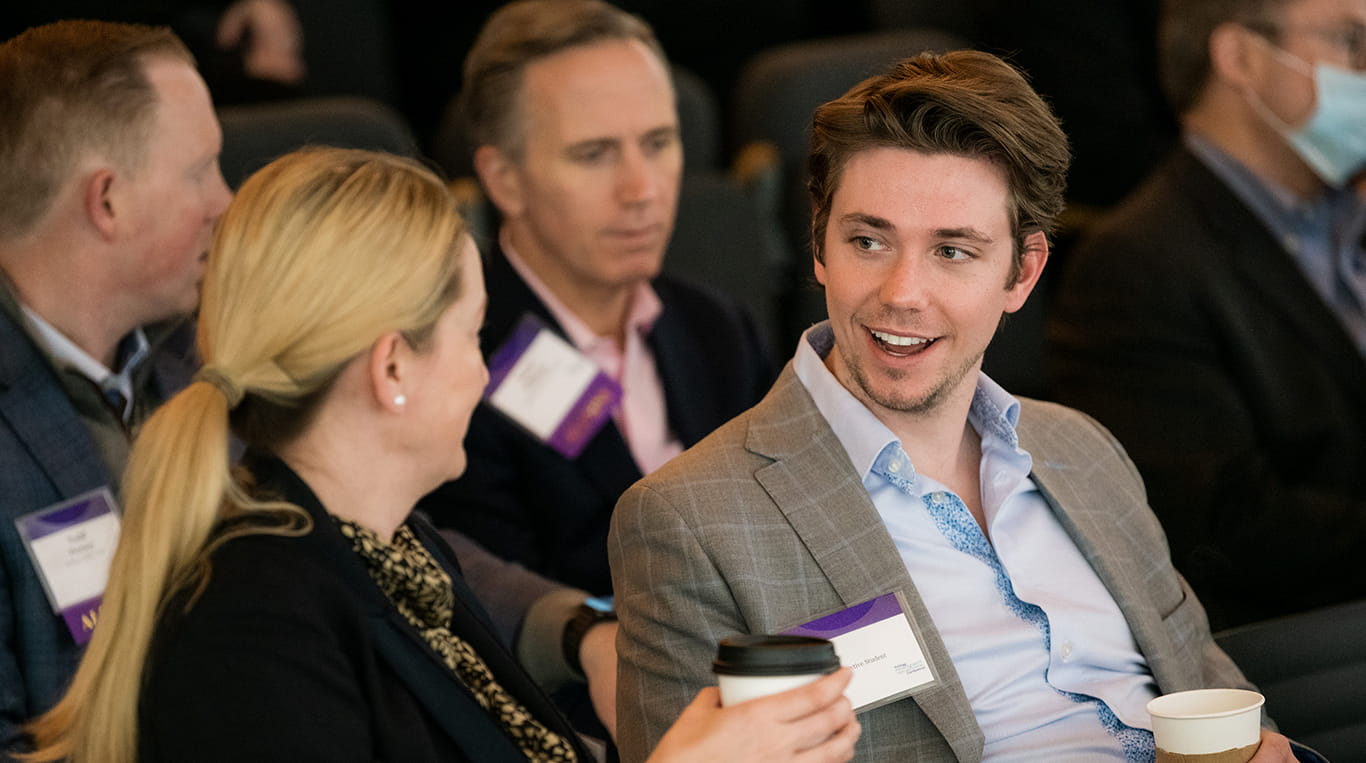 A Kellogg student and a business executive sit together engaging in a lively conversation.