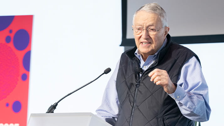 A man gives welcome remarks at a design event for business school students