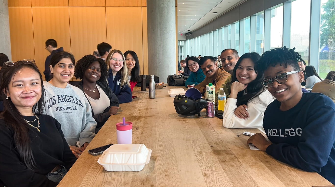 Kellogg MBA students sitting at a long table at the Global Hub's cafeteria