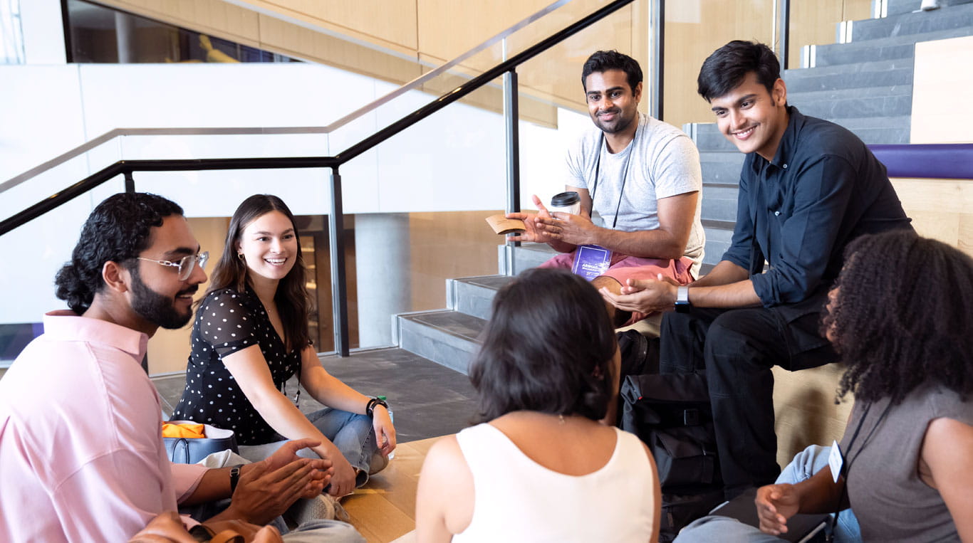Business students at Kellogg sitting around on stairs at the Global Hub