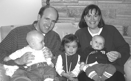 Dave Wienke (husband of Cory Mann '99) holds daughter Kate; Emily Yoshida, daughter of Eileen Yoshida '99 and James Gardner '95, squeezes in the middle; and Sprague Callery '99 holds son Graham.