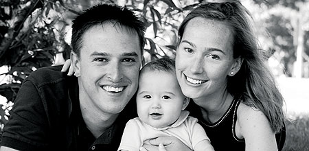 Family portrait of Ben Brown '03, Maggie Burke '03 and a very happy baby Burke.