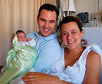 Greg Kennealey '03, wife Shannon and new daughter Emma grin for the camera.